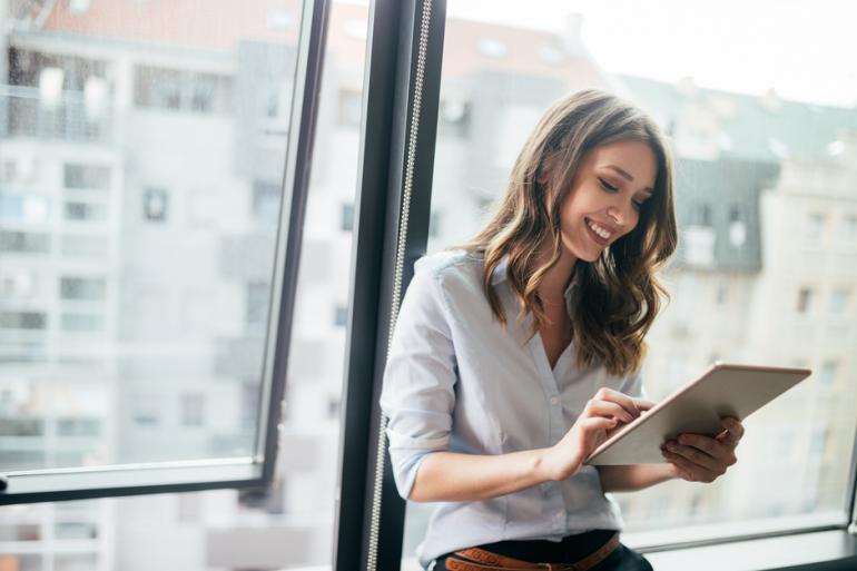 Mujer sonriendo y revisando sus apuntes